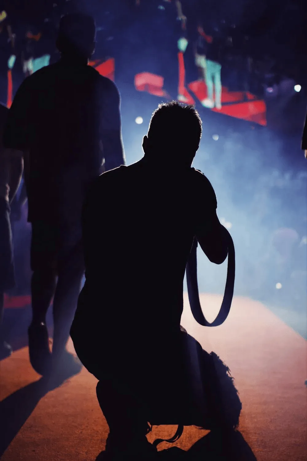 A photographer shooting a live event from the floor, under stage lights